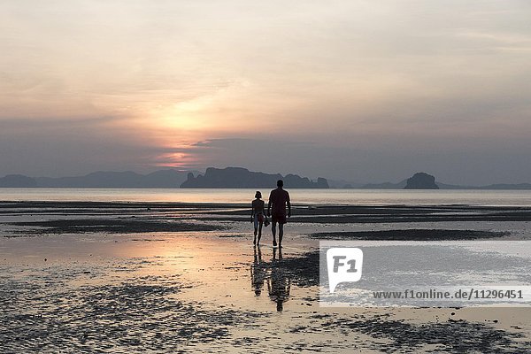 Paar bei Ebbe am Strand bei Sonnenuntergang  Tubkaek  Phang Nga Bucht  Krabi  Thailand  Asien