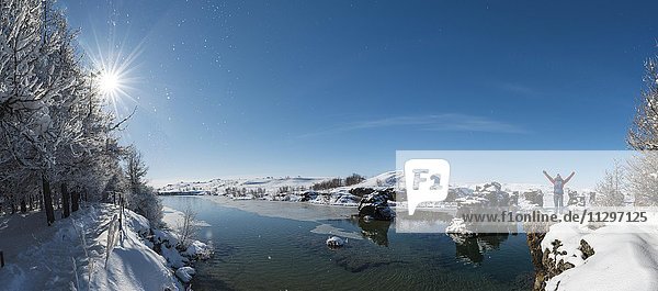 Hiker with arms in the air  overlooking Lake Mývatn in winter  Iceland  Europe