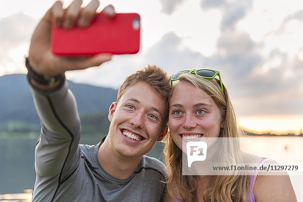 Junges Paar fotografiert sich mit einem Handy selbst  Selfie  Schliersee  Oberbayern  Bayern  Deutschland  Europa