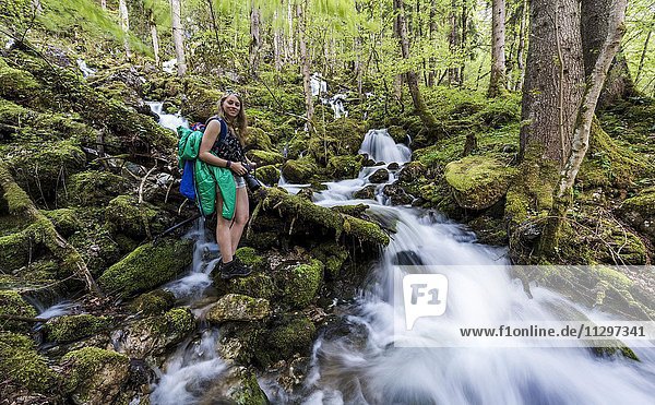 Wanderin am Bach fließt durch Wald Röthbach Röthbachfall Schönau am Königssee Berchtesgaden Bayern Oberbayern Deutschland Europa