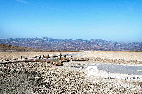 People on a jetty at Badwater Basin  the lowest point in North America  with Panamint Range  Black Mountains  Death Valley  Mojave Desert  California  USA  North America