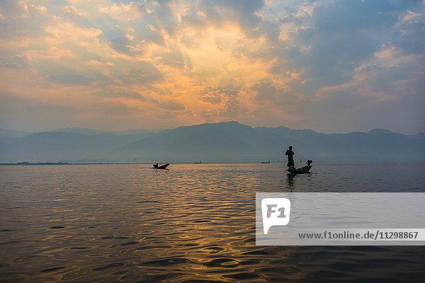 Einheimischer Intha Fischer  Einbeinruderer mit Boot  Sonnenaufgang  Morgendämmerung  Inle See  Inle Lake  Shan Staat  Myanmar  Asien