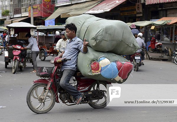 Man with moped and large sacks  Phnom Penh  Cambodia  Asia