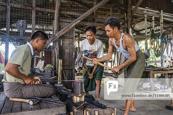 Einheimische hämmern mit Hammern auf glühendes Metallstück  Schmied  Schmiede  Inle Lake  Inle See  Shan Staat  Myanmar  Asien