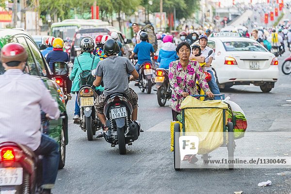 Frau läuft im Chaotischen Straßenverkehr  Rollerfahrer  Ho-Chi-Minh-Stadt  H? Chí Minh  Vietnam  Asien