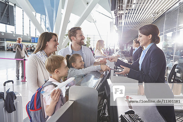 Kundenbetreuer bei der Kontrolle von Familientickets am Flughafen-Check-in-Schalter