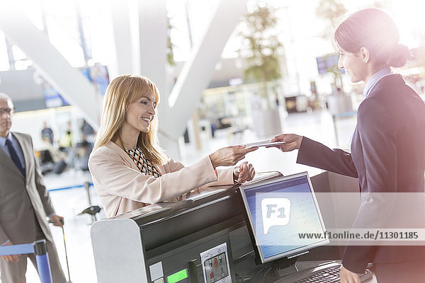 Kundenbetreuerin beim Check-in am Flughafen Check-in-Schalter
