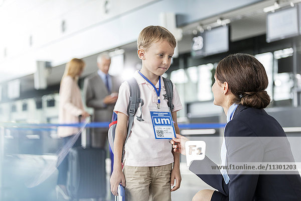 Flugbegleiterin im Gespräch mit Kinderreisenden am Flughafen