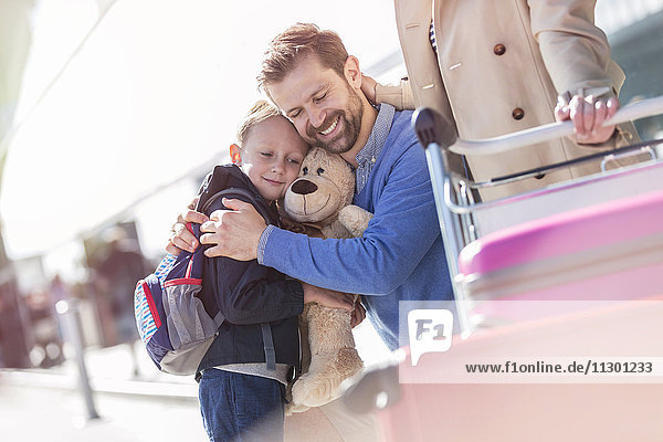 Vater und Sohn umarmen sich außerhalb des Flughafens