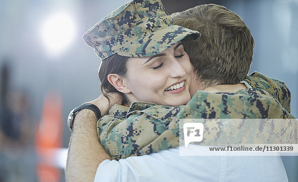 Husband greeting hugging soldier wife