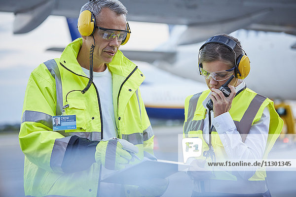 Bodenpersonal der Flugsicherung mit Zwischenablage auf dem Rollfeld des Flughafens