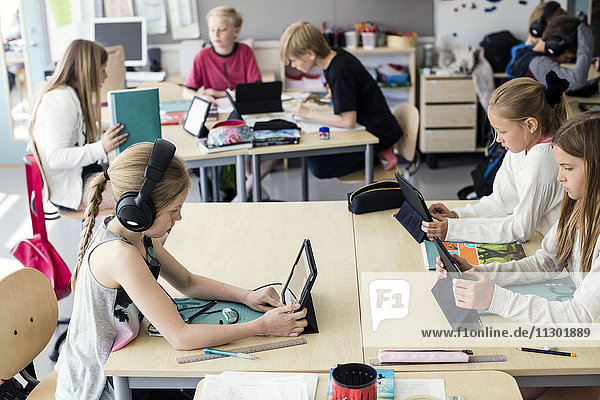 Schülerinnen und Schüler mit digitalem Tablett im Klassenzimmer