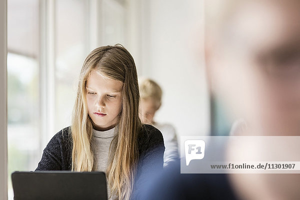 Mädchen mit digitalem Tablett im Klassenzimmer