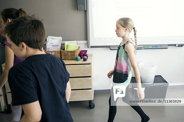 Schulkinder die im Klassenzimmer gegen das Whiteboard laufen