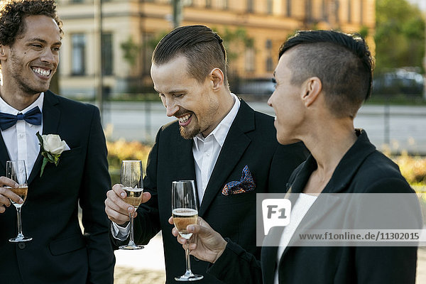 Glückliche Freunde mit Champagner bei der Hochzeitszeremonie