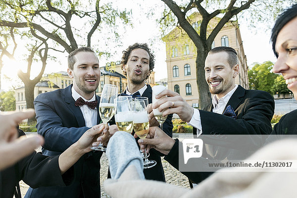 Fröhliche Freunde stoßen während der Hochzeitszeremonie auf Champagner an.