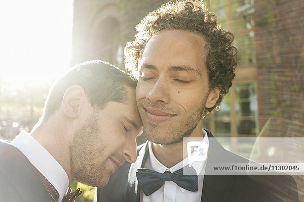 Close-up of newlywed gay couple with eyes closed