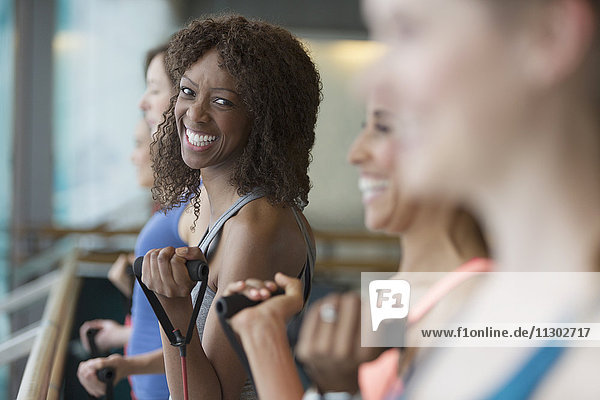 Portrait lächelnde Frau beim Training mit Widerstandsband im Fitnessstudio
