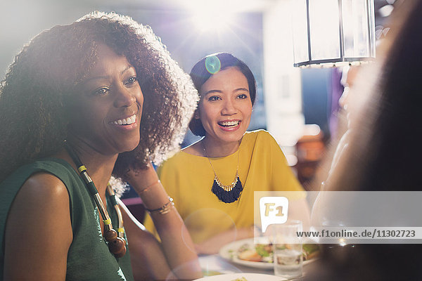 Frauenfreunde beim Reden und Essen am Restauranttisch