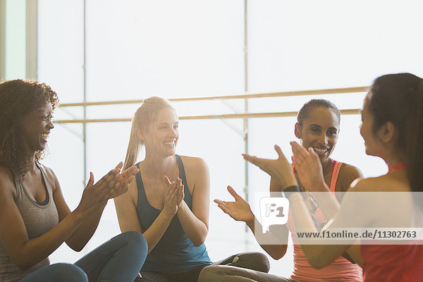 Lächelnde Frauen klatschen im Fitnessstudio der Übungsklasse