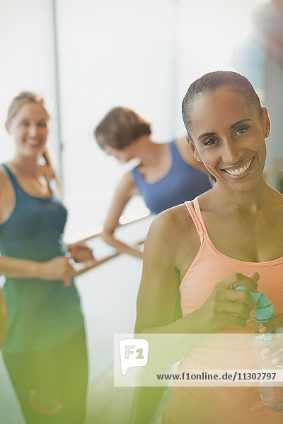 Portrait lächelnde Frau trinkt Wasser im Fitnessstudio der Übungsklasse