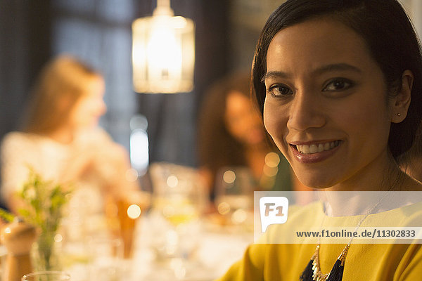 Nahaufnahme Porträt lächelnde Frau beim Essen mit Freunden am Restauranttisch