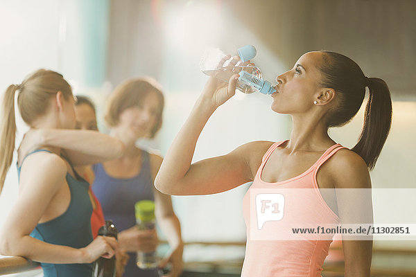 Frau trinkt Wasser im Fitnessstudio der Gymnastikklasse