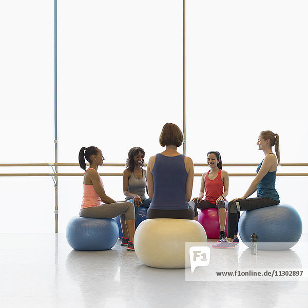 Frauen auf Fitnessbällen im Kreis im Fitnessstudio der Übungsklasse