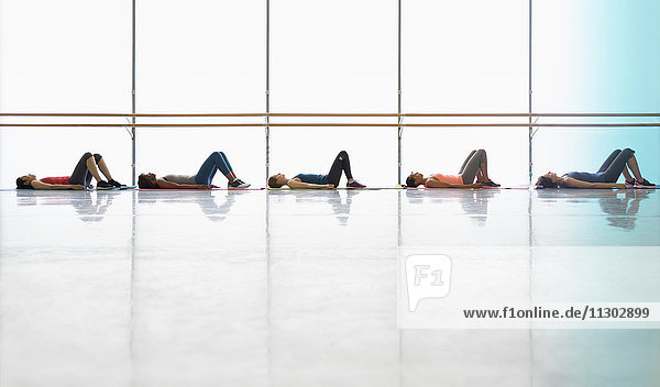 Frauen liegend auf Yogamatten im Fitnessstudio der Gymnastikklasse