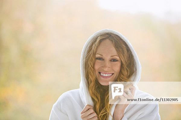 Portrait smiling woman wearing hooded bathrobe
