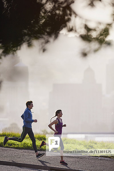 Läuferpaar auf sonnigem städtischen Bürgersteig