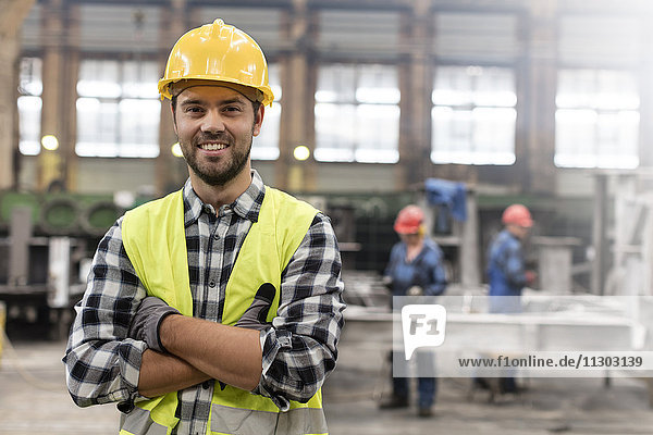 Porträt eines lächelnden  selbstbewussten Stahlarbeiters in der Fabrik