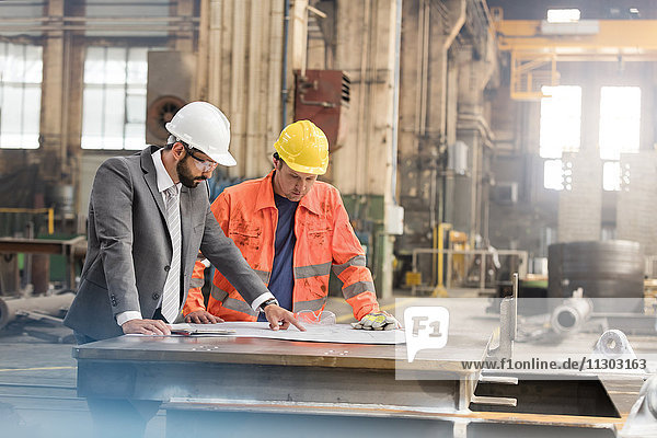 Manager und Stahlbauingenieur bei der Begutachtung von Bauplänen in der Fabrik