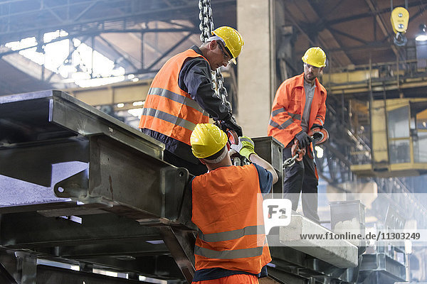 Stahlarbeiter beim Befestigen des Kranhakens am Stahl im Arbeiter