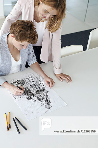 Designerinnen zeichnen Skizze im Konferenzraum