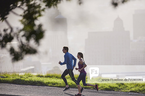 Läuferpaar läuft auf einer sonnigen städtischen Straße