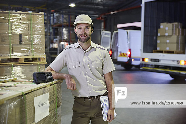 Portrait confident truck driver worker at distribution warehouse loading dock