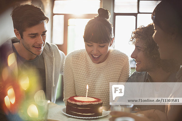 Junge erwachsene Freunde feiern ihren Geburtstag mit Kuchen und Kerzen