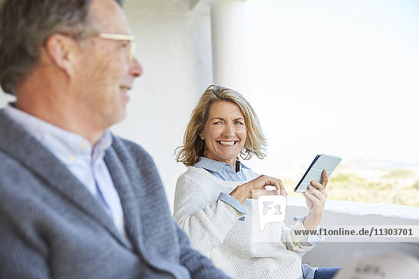 Älteres Paar benutzt digitales Tablet auf der Terrasse
