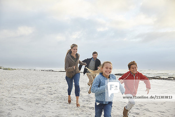 Playful family running on winter beach