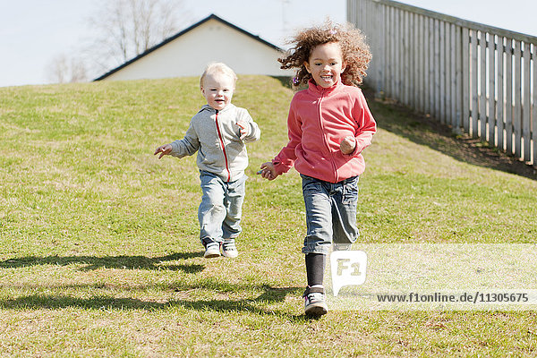 Two children running down hill