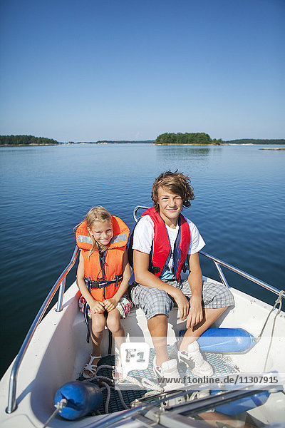 Junge und Mädchen sitzen im Boot