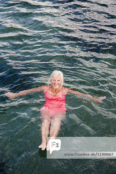 Ältere Frau schwimmt im Wasser