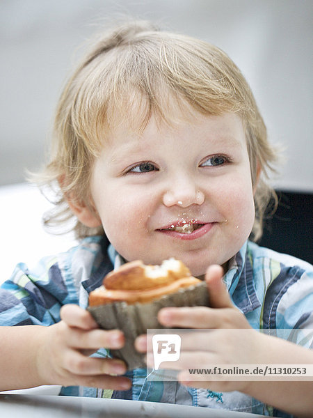 Kleiner Junge isst Muffin