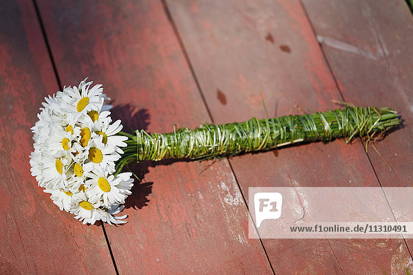 Daisy bouquet on wooden floor