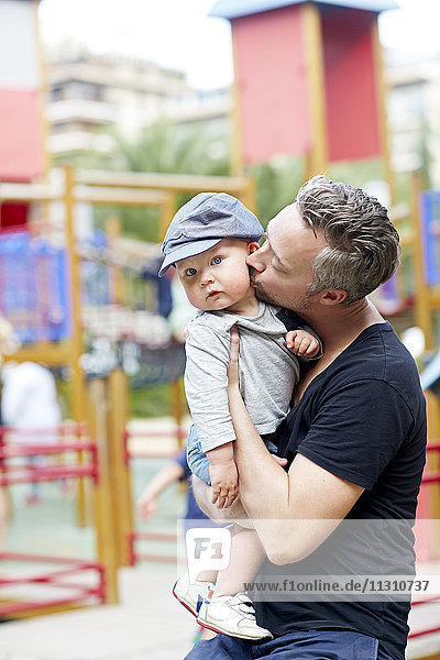 Porträt eines Vaters  der einen kleinen Jungen auf die Wange küsst
