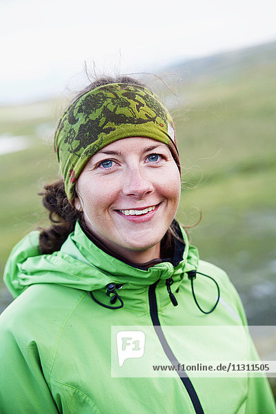 Porträt einer Frau mit grünem Stirnband und Jacke