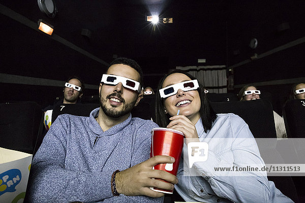 Couple with 3d glasses watching a movie in a cinema