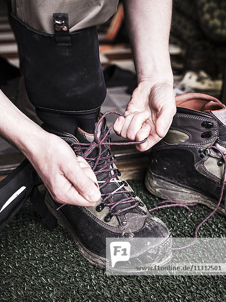 Man tying hiking shoes
