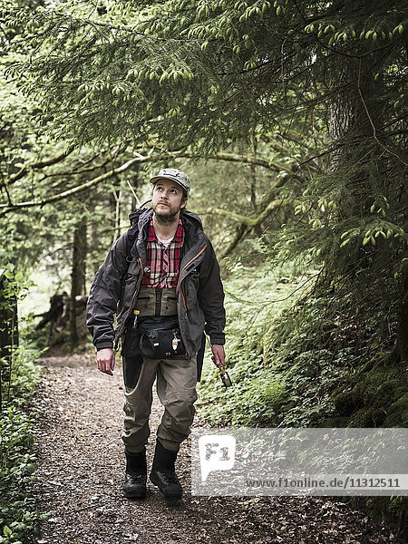 Junger Mann beim Wandern im Wald